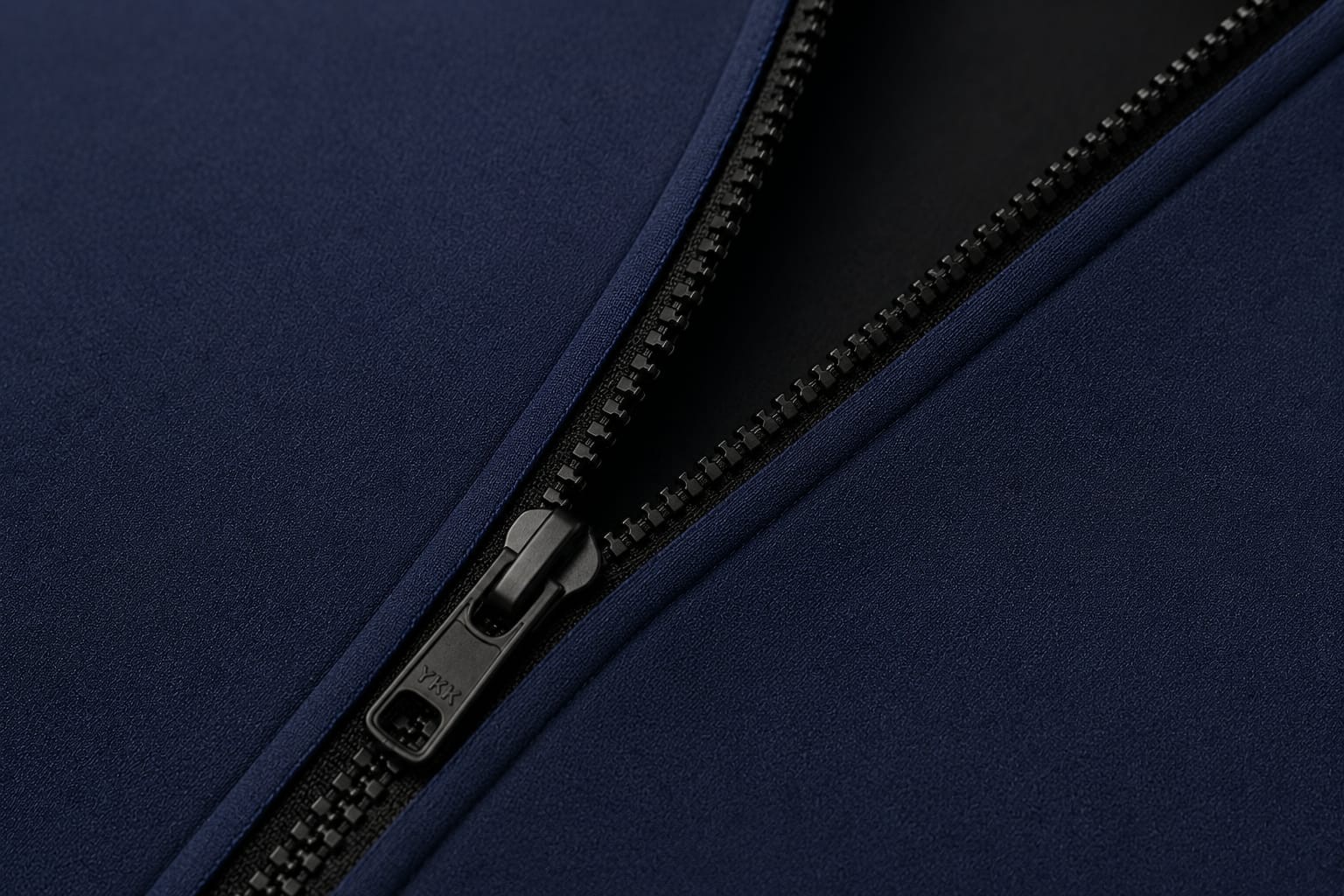 Détail d'un zip laiton et d'une broderie aileron sur néoprène marine